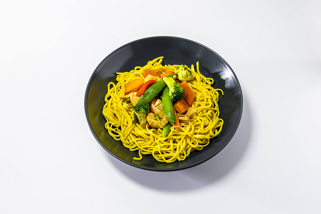 Chicken Stir Fry with vegetables and noodles in a black bowl