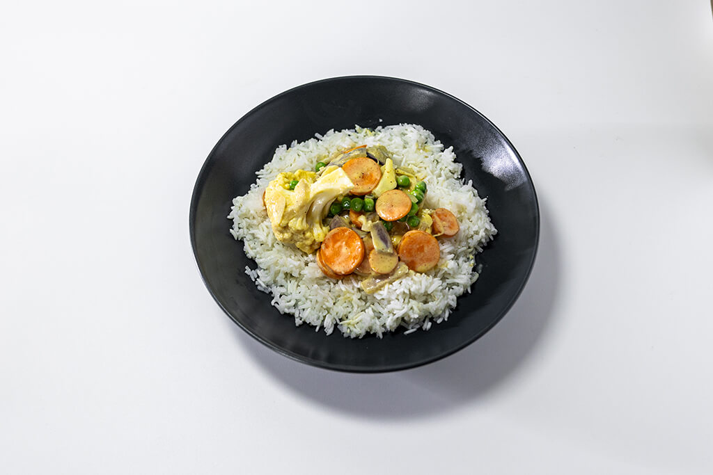 A veggie curry containing carrots, cauliflower and garden peas