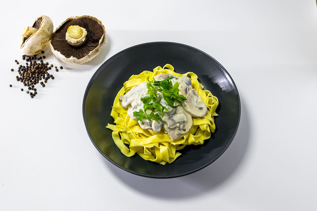 Creamy Mushroom Tagliatelle with mushrooms and black pepper as decorations