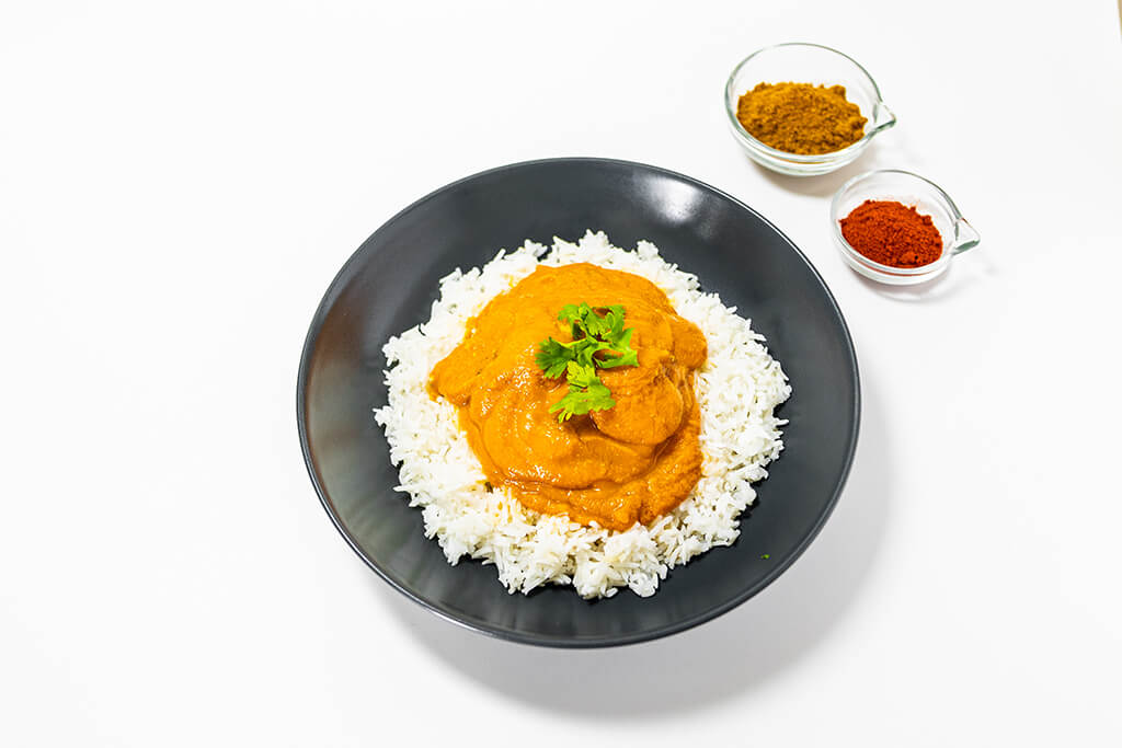 Chicken Tikka on a bed of basmati rice with spices as decorations